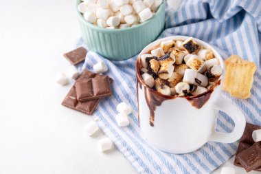 Marshmallow, graham kraker ve çikolatalı sütlü kahve, sıcak çikolata ya da latte bardağı.