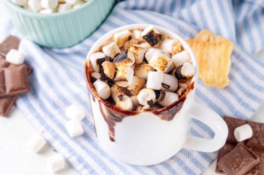 Marshmallow, graham kraker ve çikolatalı sütlü kahve, sıcak çikolata ya da latte bardağı.