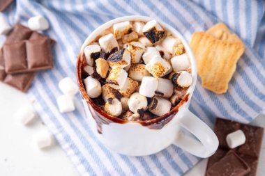 Marshmallow, graham kraker ve çikolatalı sütlü kahve, sıcak çikolata ya da latte bardağı.