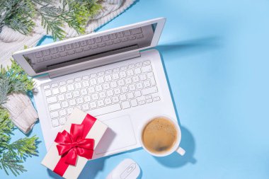Kış ve Noel ofis çalışma alanı dizüstü bilgisayarı, not defteri, örgü eldivenler, kazak ya da ekose, Noel ağacı dalları, hediye kutusu, iş yerindeki düz konum üzerine dekorasyon üst görünüm alanı