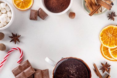Sıcak çikolata yapmak için gerekli malzemeler, geleneksel kış kakaosu lezzetli içecekler. Çikolata parçaları, kakao tozu, süt, marşmelov, baharatlar, tarçın, fındık, kurutulmuş portakal, üst görünüm kopya alanı