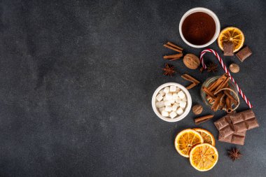 Sıcak çikolata yapmak için gerekli malzemeler, geleneksel kış kakaosu lezzetli içecekler. Çikolata parçaları, kakao tozu, süt, marşmelov, baharatlar, tarçın, fındık, kurutulmuş portakal, üst görünüm kopya alanı