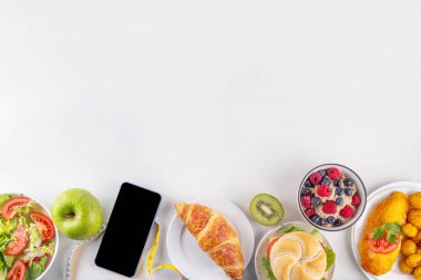 Sağlıklı ve sağlıksız yiyecek tabakları, meyveler, sebzeler, tatlı, donut ve hamburger içeren kalori hesabı diyeti. Kalori sayımı, gıda kontrol konsepti