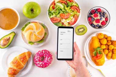 Sağlıklı ve sağlıksız yiyecek tabakları, meyveler, sebzeler, tatlı, donut ve hamburger içeren kalori hesabı diyeti. Kalori sayımı, gıda kontrol konsepti