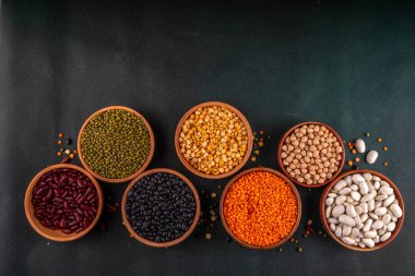 Çeşitli kuru fasulyeler, mercimek, mung, nohut, ahşap kaselerde bezelye çeşitleri. Legumes beyaz masa üst görünümünde. Vegan protein kaynakları yiyecek, kopyalama alanı