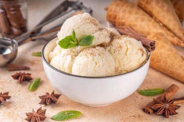Hindistan 'da soğuk yaz Garam Masala Gelato tatlısı, Hindistan' da üç baharatlı dondurma, beyaz seramik kasede, nane yaprakları, baharatlar ve kremalı dondurma külahları.