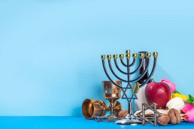 Passover, Pesah background. jewish Easter Passover spring holiday celebration, with accessories - menorah, matzo, spring flowers, wine bottle, gold wine glass, jewish david stars