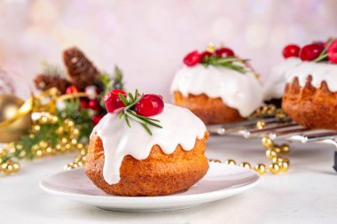Porsiyonlu Noel çöreği, zencefilli çikolata ve vanilyalı mini noel pastası üzerine şeker sosu, kızılcık ve biberiye süslemesi.