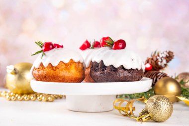 Porsiyonlu Noel çöreği, zencefilli çikolata ve vanilyalı mini noel pastası üzerine şeker sosu, kızılcık ve biberiye süslemesi.