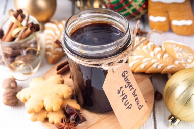 Kavanozda ev yapımı zencefilli ekmek şurubu, Noel kurabiyeleri ve pasta, bal, şeker, baharat karışımı, mutfak masasında zencefilli kurabiyeler ve Noel süslemeleri. 