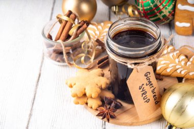 Kavanozda ev yapımı zencefilli ekmek şurubu, Noel kurabiyeleri ve pasta, bal, şeker, baharat karışımı, mutfak masasında zencefilli kurabiyeler ve Noel süslemeleri. 