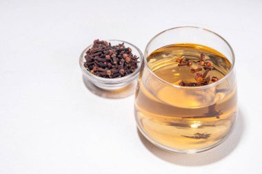 Karanfil suyu ya da çay, organik içecekler. Ayurvedik, antiseptik, iltihap önleyici ve antioksidan içecekler, camda demlenmiş kuru karanfil ilacı.