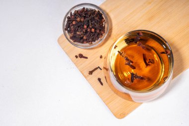 Karanfil suyu ya da çay, organik içecekler. Ayurvedik, antiseptik, iltihap önleyici ve antioksidan içecekler, camda demlenmiş kuru karanfil ilacı.