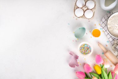 Paskalya pastası arka planı, Paskalya kurabiyesi, pasta, çikolatalı tatlı, şeker parçacıkları, fırın malzemeleri, un, yumurta, süt, oklavalı iğne, bahar çiçekleri üst görünümü