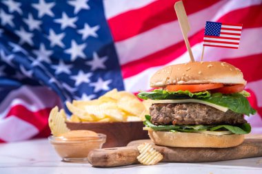Lezzetli çizburger, patates kızartması ve soslu vatansever Amerikan bayrağı. 4 Temmuz, Bağımsızlık Günü piknik yemeği, ABD temalı bbq hamburger fotokopi alanı