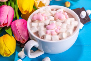 Funny Easter hot chocolate with Easter. Funny hot chocolate with easter symbols - rabbit feet, rabbit, flowers, marshmallow lamb. Cute cocoa recipe idea for Easter kids party 