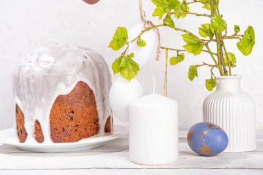 Paskalya Ortodoks Hıristiyan bayramı geçmişi, ahşap haç sembolü, şekerli Paskalya pastası, renkli boyalı yumurta ve çiçek açan yapraklı bahar dalları