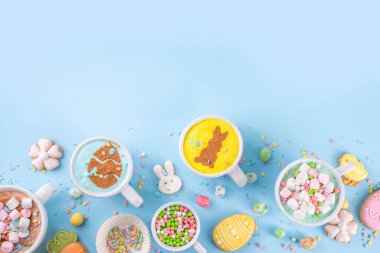 Paskalya partisi, kahvaltı, öğle yemeği için sıcak tatlı içecekler. Paskalya menüsü. Pembe, sarı, mavi, kahverengi, lokum kaplı sıcak çikolata bardakları, çikolatalı tavşan, latte yüzeyinde paskalya yumurtaları.