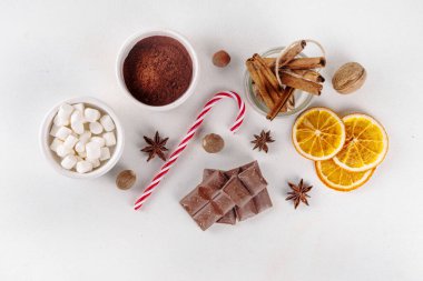 Sıcak çikolata yapmak için gerekli malzemeler, geleneksel kış kakaosu lezzetli içecekler. Çikolata parçaları, kakao tozu, süt, marşmelov, baharatlar, tarçın, fındık, kurutulmuş portakal, üst görünüm kopya alanı