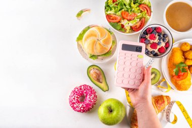 Sağlıklı ve sağlıksız yiyecek tabakları, meyveler, sebzeler, tatlı, donut ve hamburger içeren kalori hesabı diyeti. Kalori sayımı, gıda kontrol konsepti