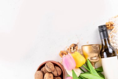 Hamursuz Bayramı geçmişi. Geleneksel Yahudi ekmek matzası, kırmızı koşer şarabı, ceviz, bahar güzel çiçekleri. Yahudi Paskalya Pesah bahar tatili arka plan kopya alanı