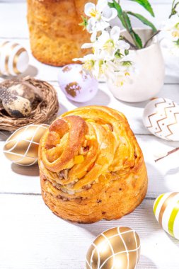 Geleneksel tatil pastaları ile Paskalya pastaları - Kraffin, panettone, paska kulich, Paskalya yumurtaları, beyaz ahşap masa üzerinde bahar çiçekleri, bahar bayramı Paskalya tebrik kartı arka planı