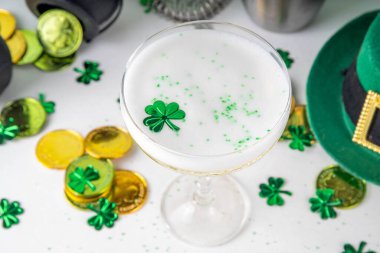 Patrick Day içki menüsü, parti davetiyesi, yonca, yeşil şeker parçacıkları ile süslenmiş altın yeşil kokteyl, Aziz Patrick Günü kutlamaları için, şenlikli dekorlar ve bar malzemeleriyle