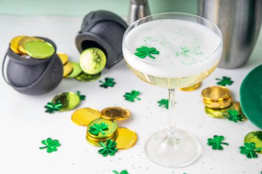 Patrick Day içki menüsü, parti davetiyesi, yonca, yeşil şeker parçacıkları ile süslenmiş altın yeşil kokteyl, Aziz Patrick Günü kutlamaları için, şenlikli dekorlar ve bar malzemeleriyle
