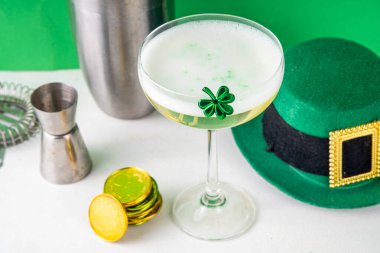 Patrick Day içki menüsü, parti davetiyesi, yonca, yeşil şeker parçacıkları ile süslenmiş altın yeşil kokteyl, Aziz Patrick Günü kutlamaları için, şenlikli dekorlar ve bar malzemeleriyle