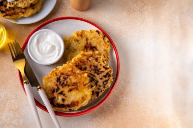 Vegetarian comfort food, potato pancakes. Traditional european vegetable dish, potato fritters, cutlets, latkes (flapjacks, hash brown or potato vada) with sour cream clipart