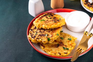 Vegetarian comfort food, potato pancakes. Traditional european vegetable dish, potato fritters, cutlets, latkes (flapjacks, hash brown or potato vada) with sour cream clipart