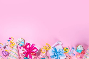 Mutlu yıllar tebrik kartı geçmişi. Renkli tatil aletleri olan düz yatak - doğum günü partisi şapkaları, şişirme makineleri, hediye kutuları, balonlar, buharlı mumlar, pembe arka plan fotokopi alanı