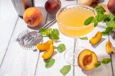 Şeftalili martini ya da margarita ya da limonata soğuk meyve suyu, nane ve limonlu yaz meyve suyu kokteyli, beyaz ahşap masa.
