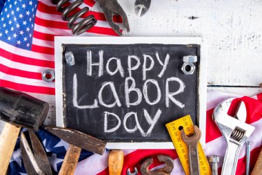 Amerikan Ulusal Vatansever İşçiler Mutlu İşçi Bayramı tatili geçmişi. Ahşap zemin üzerinde yıldızlı inşaat ve imalat araçları, kırmızı beyaz mavi çizgili Amerikan bayrağı