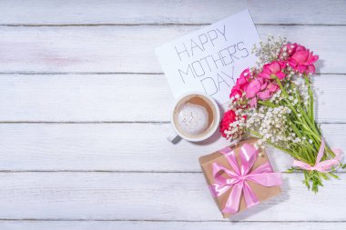 Anneler günü tebrik kartı, davetiye arkaplanı, güzel ranunculus çiçeği buketi, sevimli el işi kağıt hediye paketi ve not: Mutlu anneler günleri, beyaz arkaplanda kopyalama alanı