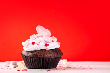 Valentine day tasty double chocolate cupcakes treat with whipped cream, heart shaped marshmallow and sugar sprinkles clipart