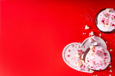 Valentine day tasty double chocolate cupcakes treat with whipped cream, heart shaped marshmallow and sugar sprinkles clipart