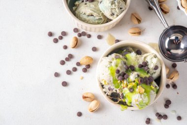 Dubai çikolatalı dondurma, tahini, kataifi ve çikolatalı dondurma, Dubai çikolatalı şurup soslu ve fıstıklı, beyaz mutfak masasında,