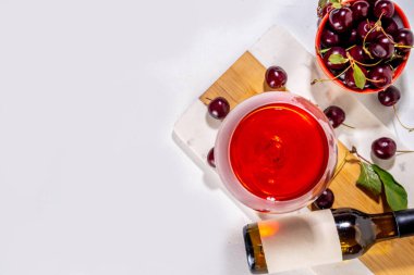 Tatlı alkollü kiraz şarabı, ev yapımı kiraz şarabı ya da taze kirazlı likör mutfak masasında fotokopi alanı.