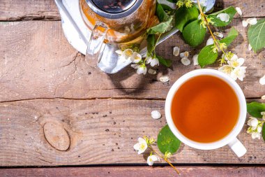 Bitkisel yasemin çiçeği çayı. Cam çaydanlıkta yasemin yeşili çay ve taze yasemin çiçekli beyaz çay fincanı.