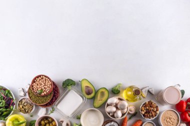 Bitki bazlı keto gıda arka planı, düşük karbonhidratlı vejetaryen keto diyet malzemeleri, sağlıklı vejetaryen yağ ve protein kaynağı. Çeşit çeşit yeşil sebzeler, fındık, baklagiller, yağ, hindistan cevizi, fıstık, fıstık ezmesi