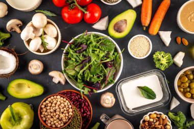 Bitki bazlı keto gıda arka planı, düşük karbonhidratlı vejetaryen keto diyet malzemeleri, sağlıklı vejetaryen yağ ve protein kaynağı. Çeşit çeşit yeşil sebzeler, fındık, baklagiller, yağ, hindistan cevizi, fıstık, fıstık ezmesi