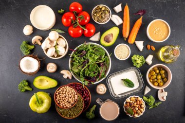 Bitki bazlı keto gıda arka planı, düşük karbonhidratlı vejetaryen keto diyet malzemeleri, sağlıklı vejetaryen yağ ve protein kaynağı. Çeşit çeşit yeşil sebzeler, fındık, baklagiller, yağ, hindistan cevizi, fıstık, fıstık ezmesi