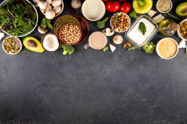 Bitki bazlı keto gıda arka planı, düşük karbonhidratlı vejetaryen keto diyet malzemeleri, sağlıklı vejetaryen yağ ve protein kaynağı. Çeşit çeşit yeşil sebzeler, fındık, baklagiller, yağ, hindistan cevizi, fıstık, fıstık ezmesi