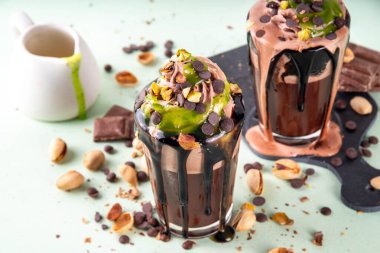 Dubai çikolatalı milkshake, çikolatalı kokteyl, çırpılmış çikolata kreması, kadaif şam fıstıklı parfe ve Dubai çikolata şurubu, çikolata damlalarıyla dolu, ezilmiş şam fıstığı.