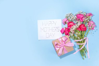 Anneler günü tebrik kartı, davetiye arkaplanı, güzel ranunculus çiçeği buketi, sevimli el işi kağıt hediye paketi ve not: Mutlu anneler günleri, beyaz arkaplanda kopyalama alanı