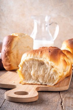 Japanese bread Shokupan, Hokkaido milk bread, or simply milk fluffy buns, on kitchen table, copy space clipart