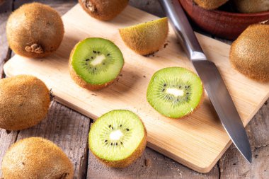 Tatlı kivi meyveleri, bütün ve dilimlenmiş, mutfak masasının üzerinde fotokopi alanı. Yeşil ve altın kivi çeşitleri 