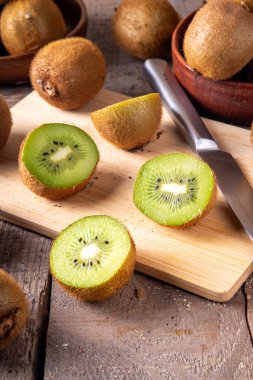 Tatlı kivi meyveleri, bütün ve dilimlenmiş, mutfak masasının üzerinde fotokopi alanı. Yeşil ve altın kivi çeşitleri 