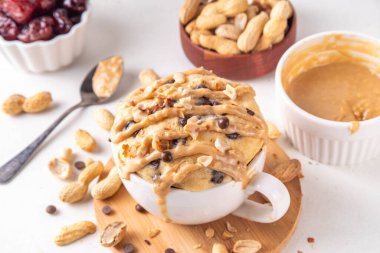 Sağlıklı vejetaryen Fıstık Ezmeli Muzlu Mugcake zengin ve lezzetli fıstık ezmeli mikrodalga fırın hurma, çikolata damlası, fıstık ezmeli ve çikolatalı kek yaptı.